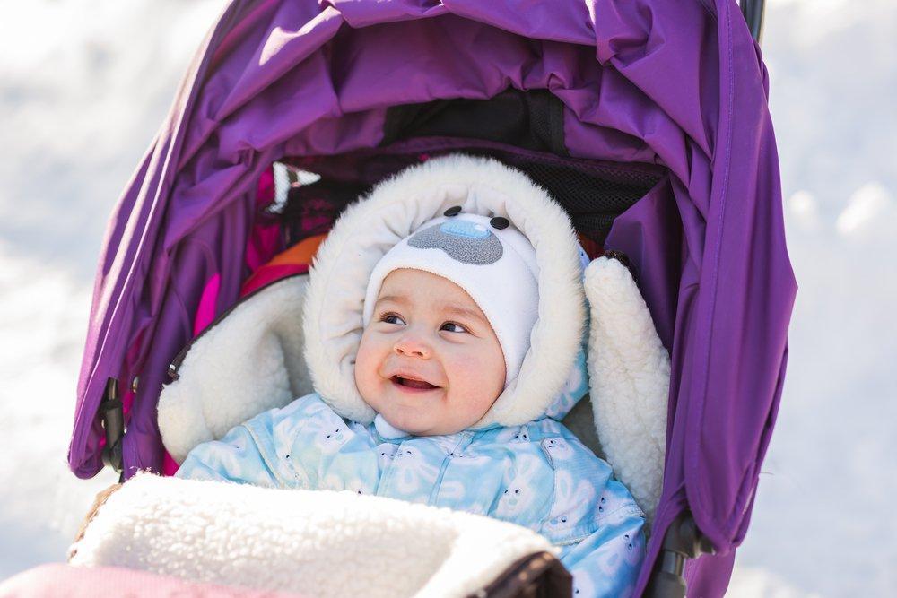 Малышка на прогулке в коляске зимой